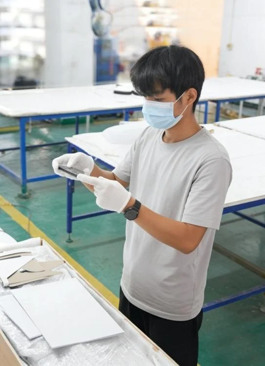 Gloved craftsperson examining a sign component