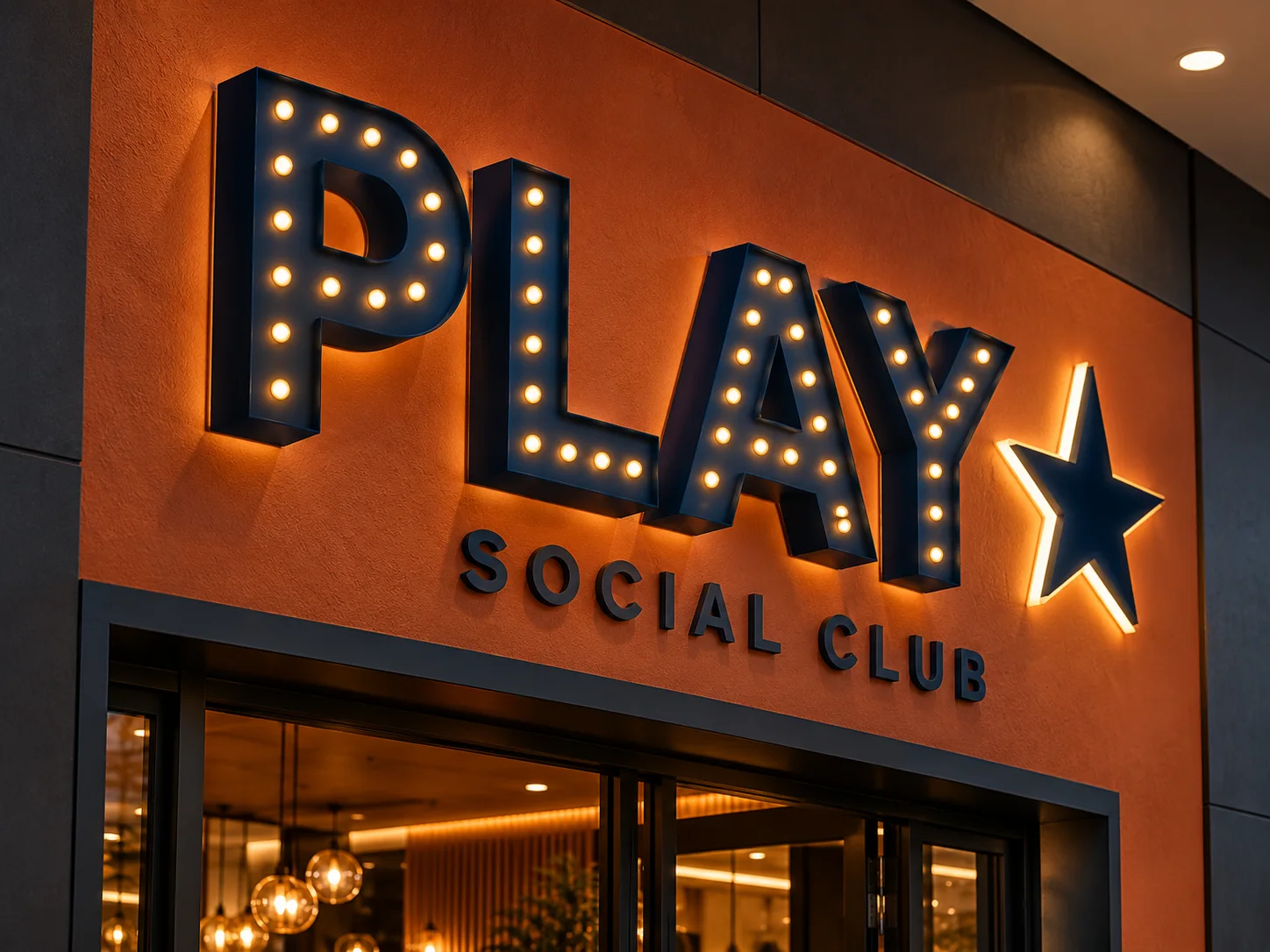 Navy PLAY dimensional letters and a star with exposed light points on an orange wall